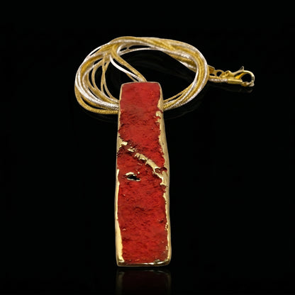 Gold-tone pendant necklace with red rectangular stone pendant and layered chain