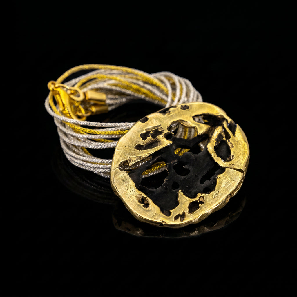 Lunar Eclipse necklace: gold round pendant with dark eclipse cutout on cord.