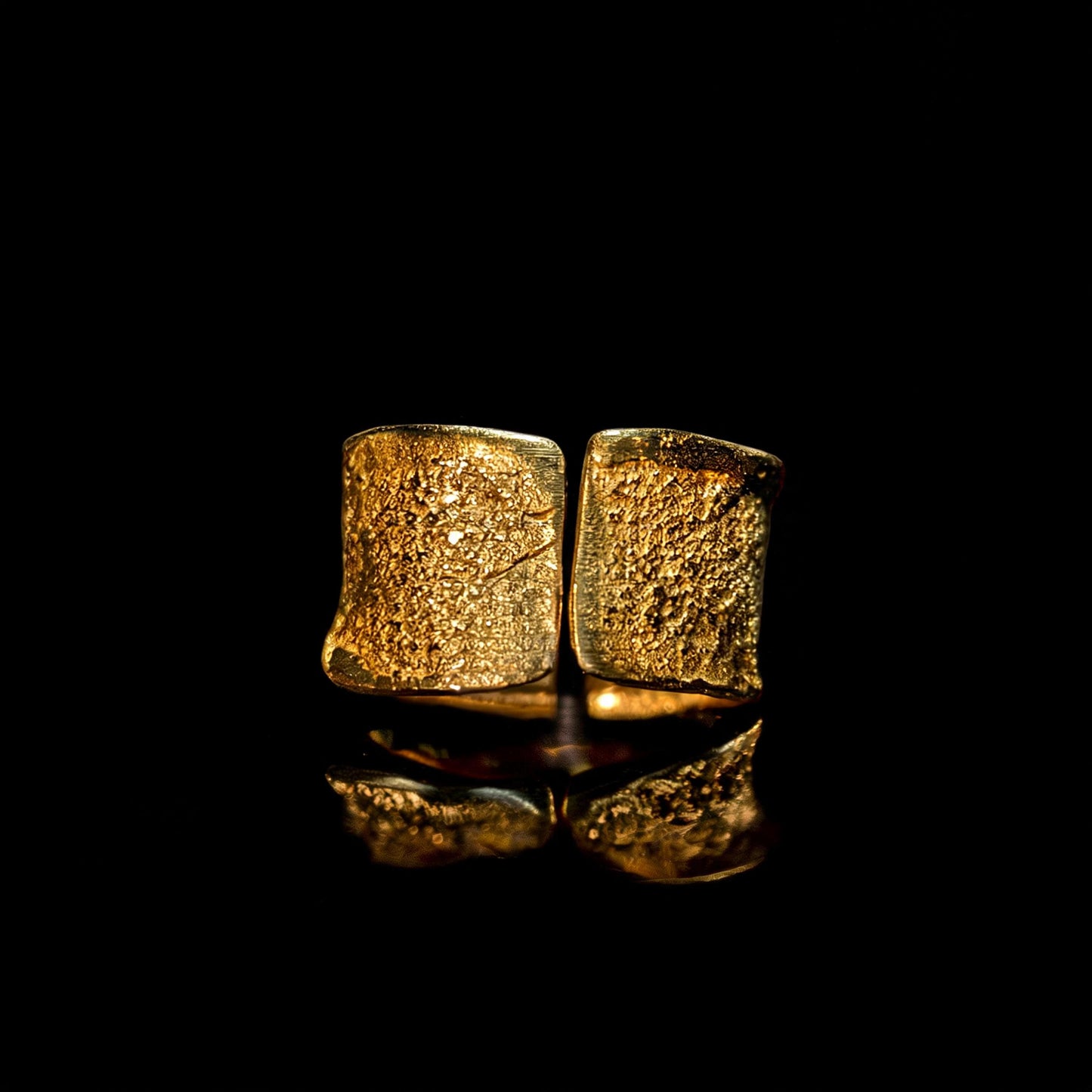 Gold hammered wide-band ring, front view with mirror-like reflection on surface