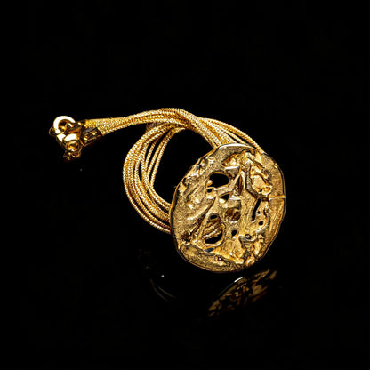 18K gold void pendant angled view on braided gold chain